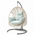 Chaise suspendue en rotin synthétique avec coussins en polyester vert pâle et support en acier